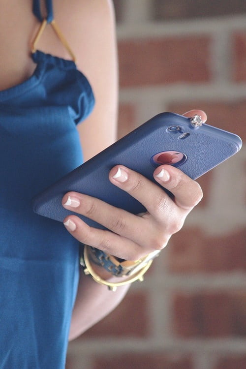 donna che utilizza un telefono cellulare con la mano