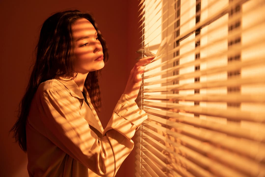 Hermosa mujer joven con luz de persiana.